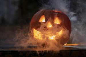 pumpkin jack o'lantern glowing in the dark and smoke